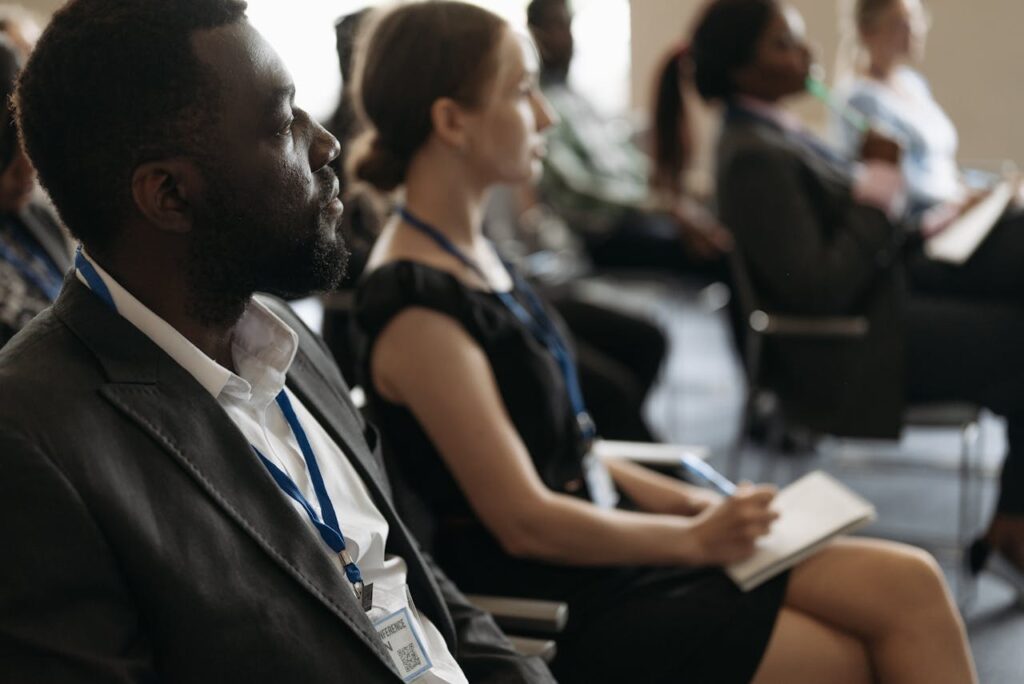 Mastering the First Impression: Your intriguing post title goes here A diverse group of professionals attentively listening at a conference seminar.